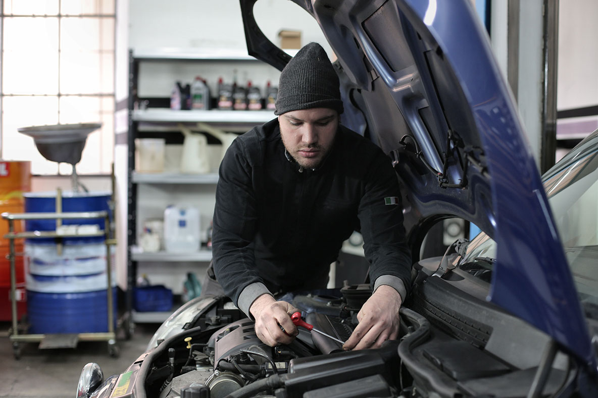 a male mechanic fixes an engine